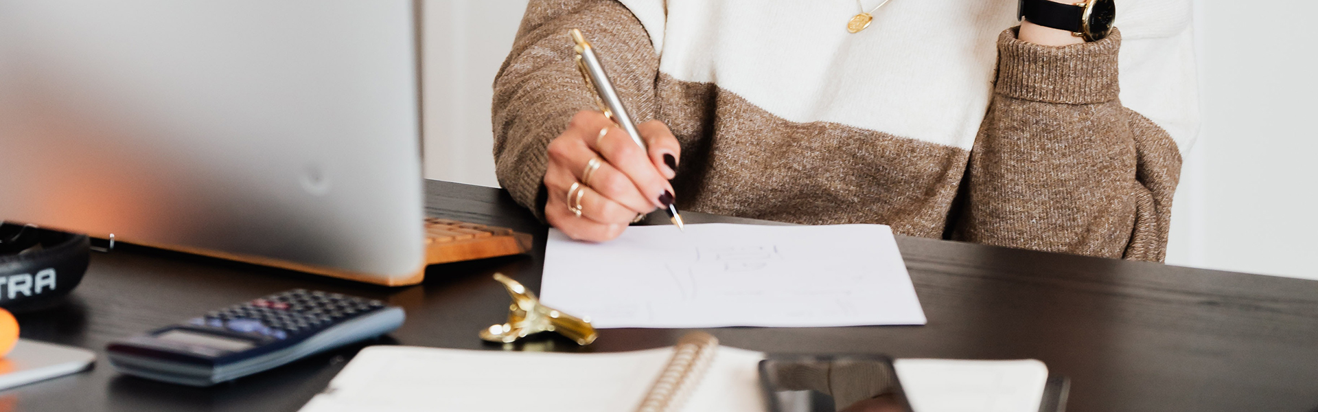 Pexels stock photo of a person at work with a calculator and writing on paper