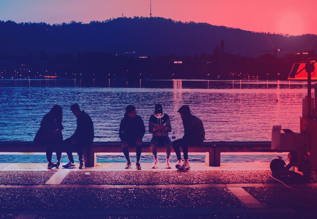 Kids sitting on a wharf, with ominous colours