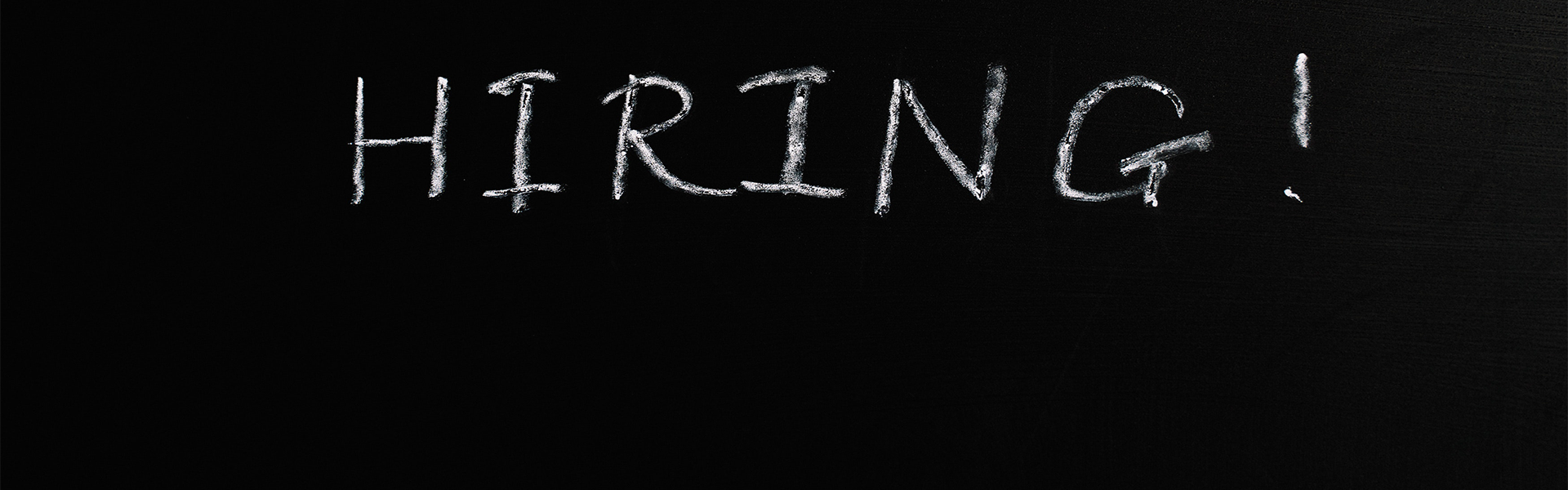 The word hiring written in chalk on a chalkboard