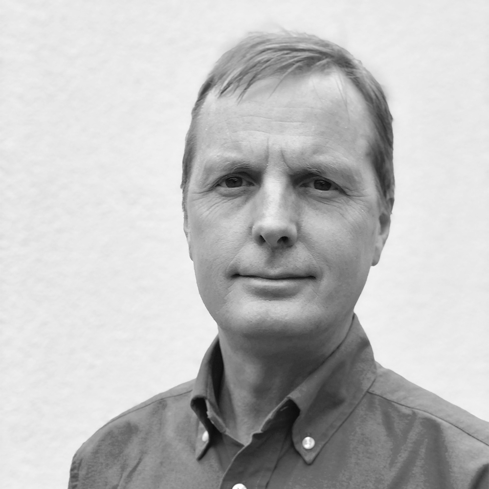 Headshot of Tom Currie against a white wall